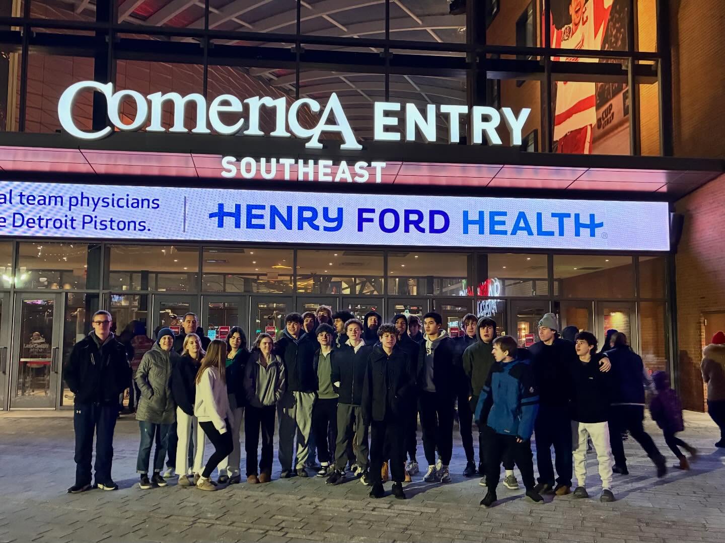Youth group outing outside the entrance to a basketball arena